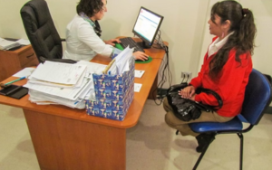 Doctora en consultorio analizando expediente en computadora con paciente femenina, especialistas en hemato-oncología y cáncer sanguíneo.